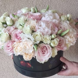 Round box arrangement of pink and white roses and peonies