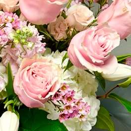 Pink roses with white hydrangeas and small purple flowers in a bouquet