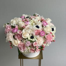 Round bouquet of pink and white flowers in a white box