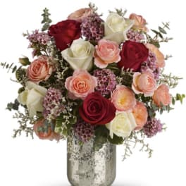 Mixed roses and ranunculus in a silver vase