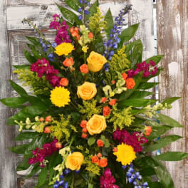 Tall standing spray with yellow, orange, magenta, and blue flowers