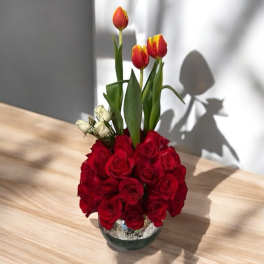 Red roses with red-yellow tulips in a glass vase