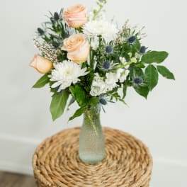 Peach roses and white daisies in a glass vase