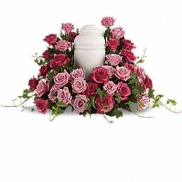 Pink and magenta roses arranged around a white urn
