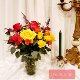 Bouquet of red, yellow, and orange roses in a glass vase