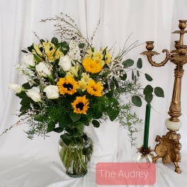 Bouquet of white roses and yellow sunflowers in a glass vase
