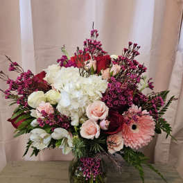 Mixed bouquet of pink and white flowers in a glass vase