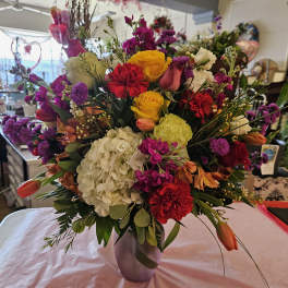 Mixed bouquet of roses, hydrangea, and tulips in a vase