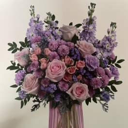 Pink and lavender bouquet in a purple glass vase