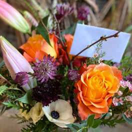 Bouquet of orange roses and white poppies in a vase