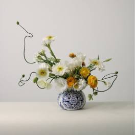 White and yellow flowers in a blue-and-white ceramic vase