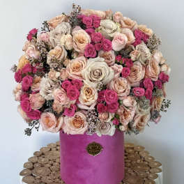Large bouquet of pink and blush roses in a magenta hatbox