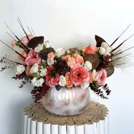 Pink and white floral arrangement in a metallic pumpkin vase