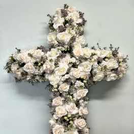 White floral cross arrangement with roses on a stand