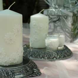 White decorative candles on ornate silver holders