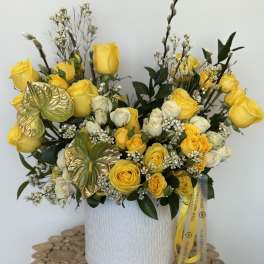 Yellow and white rose arrangement in a white textured vase