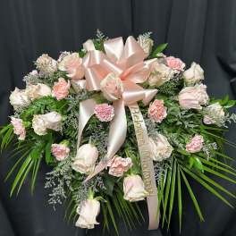 Pink and white rose spray with a satin bow and memorial ribbon