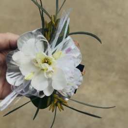 White orchid corsage with sheer ribbon and long grass-like accents