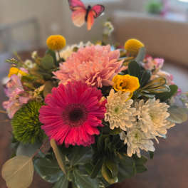 Mixed bouquet with pink and white daisies and a butterfly pick