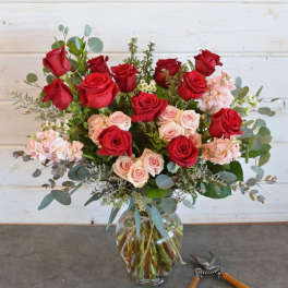 Bouquet of red and blush roses in a clear glass vase