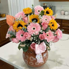 Pink gerberas and roses with sunflowers in a decorated vase