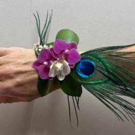 Wrist corsage with purple orchids and peacock feathers
