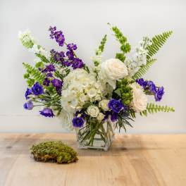 Bouquet of white and purple flowers in a clear glass vase