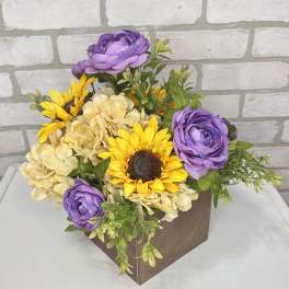 Purple and yellow flowers arranged in a brown box