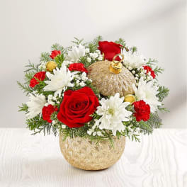 Red roses and white daisies arranged in a gold ornament-shaped vase