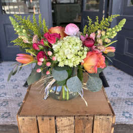 Colorful bouquet in a glass vase with roses, hydrangea, and tulips