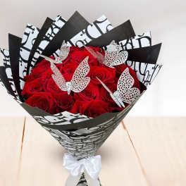 Bouquet of red roses wrapped in black-and-white paper with butterfly accents
