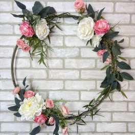 Floral wreath with pink and white roses on a metal hoop
