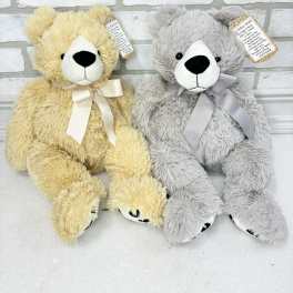Two plush teddy bears with ribbon bows, one yellow and one gray