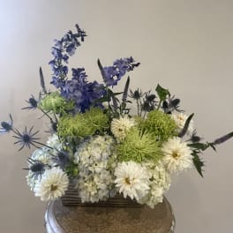 Mixed bouquet with white and green blooms in a low container