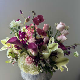 Mixed bouquet in a silver vase with pink, white, and purple blooms