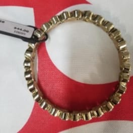 Gold scalloped hoop ornament with a price tag on red and white packaging