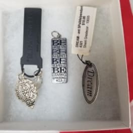 Three decorative keychain charms in a gift box