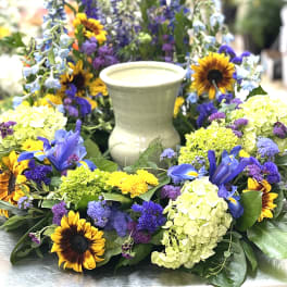 Colorful floral wreath with sunflowers and blue blooms around a candle holder