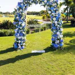 Blue and white floral arch on a lawn outdoors
