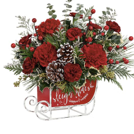 Red carnations and pinecones in a sleigh-shaped container