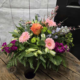 Mixed bouquet with pink gerberas, orange rose, and purple blooms