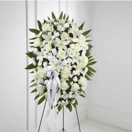 White funeral wreath on a stand with ribbon