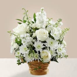 White roses and daisies arranged in a woven basket
