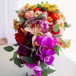 Colorful bouquet of orchids and roses with greenery