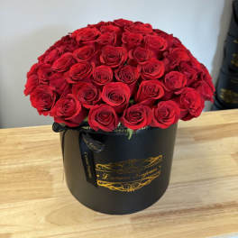 Large bouquet of red roses in a black round box
