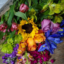 Mixed bouquet with sunflowers, roses, and alstroemeria in bright rainbow colors