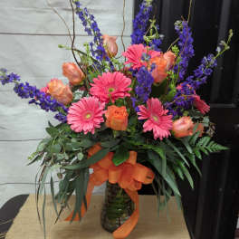 Bouquet of pink gerbera daisies and peach roses in a glass vase