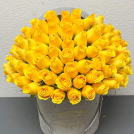 Bouquet of yellow roses in a gray hatbox