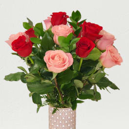 Bouquet of red and pink roses in a tall glass vase