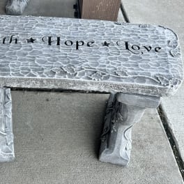 Decorative stone bench engraved with the words Faith Hope Love